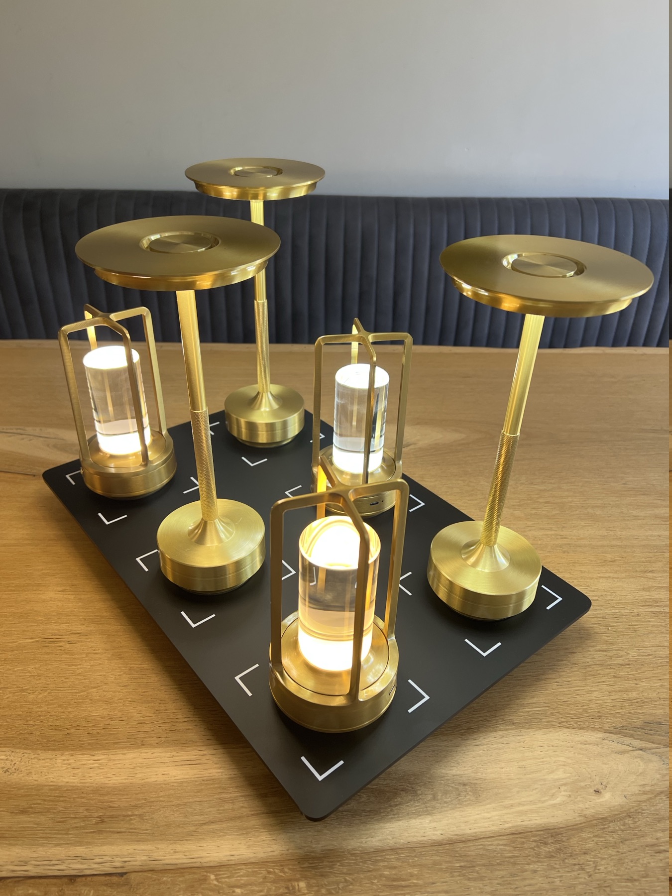Zes gouden horeca tafellampen op draadloos laadstation
